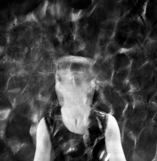 Black and white multiple exposure image of a head and torso overlaid and partially obscured by the texture of water ripples.