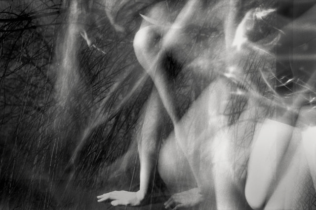 Black and white multiple exposure image of a blurred figure crawling on hands an knees.